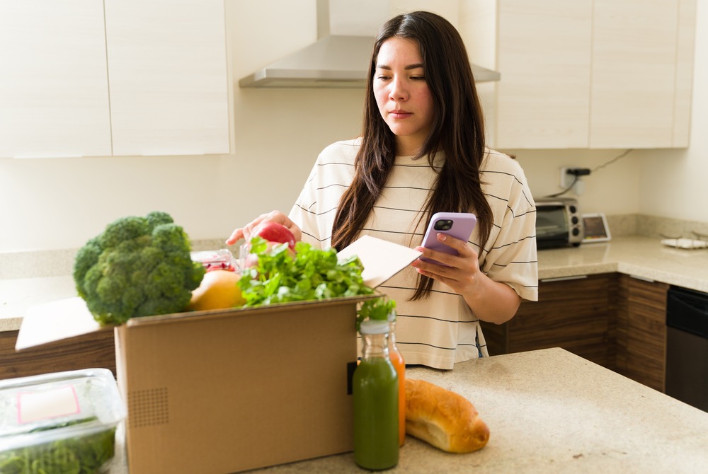 Woman standing in front of a box of vegetables