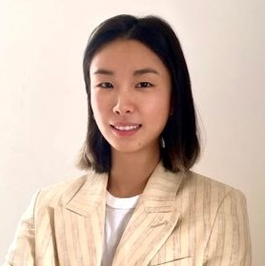 Portrait photo of Jess Gong looking at camera wearing a cream blazer